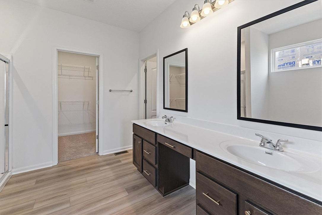 Dual vanities and a spacious walk-in closet highli