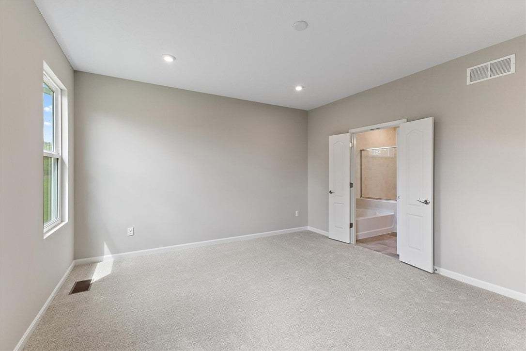 Plush carpeting and double doors leading to the en