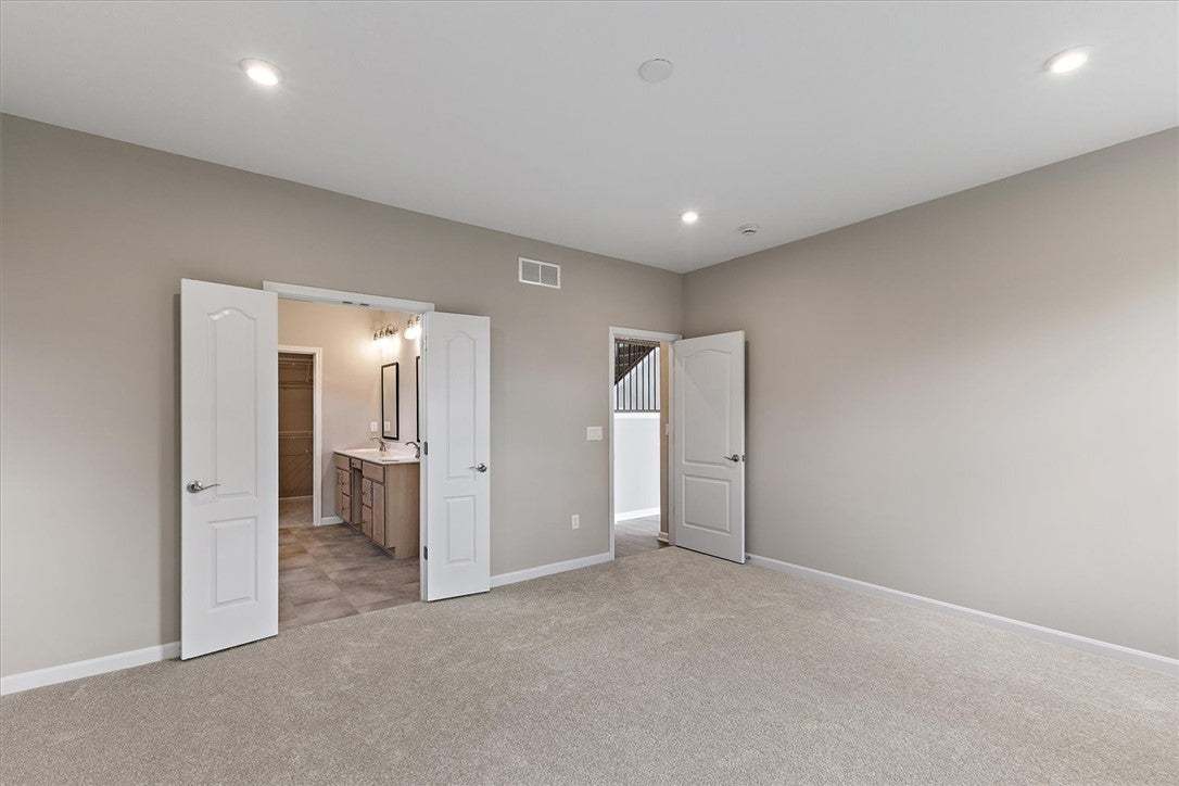 Double doors open to an attached bathroom from thi