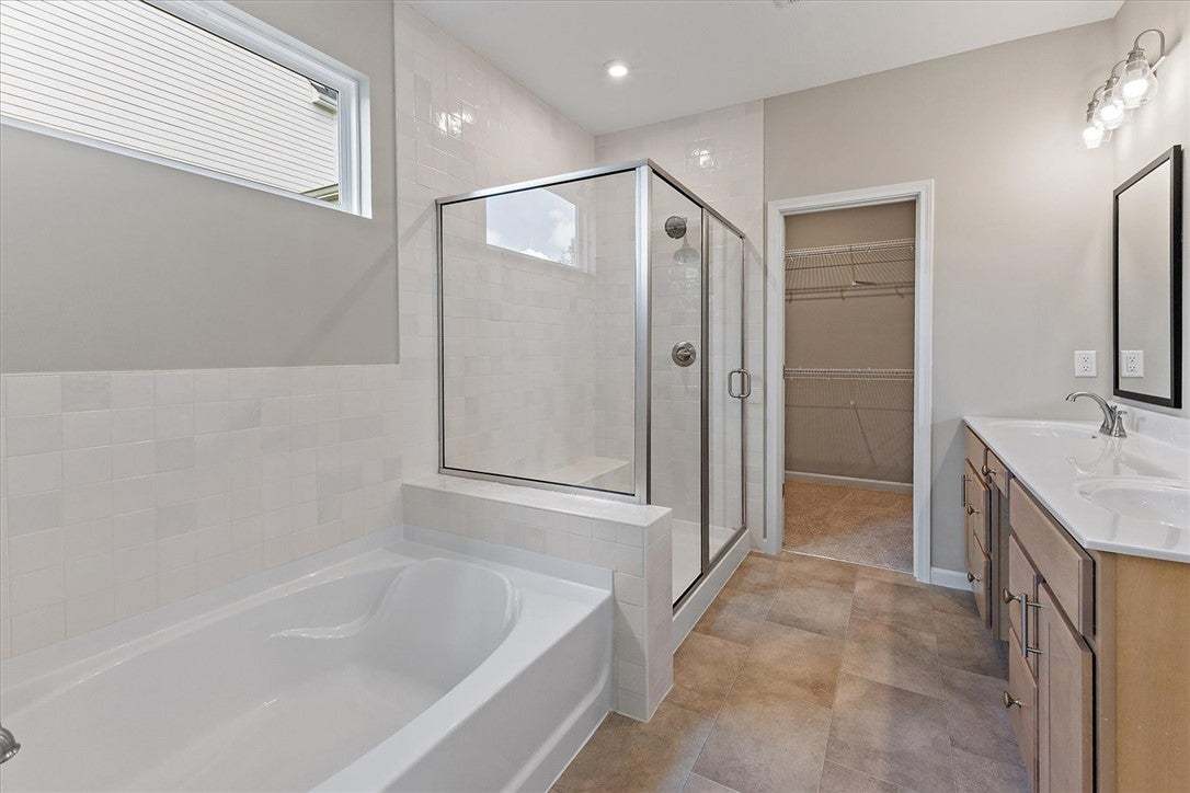 Tiled flooring pairs with a glass-enclosed shower