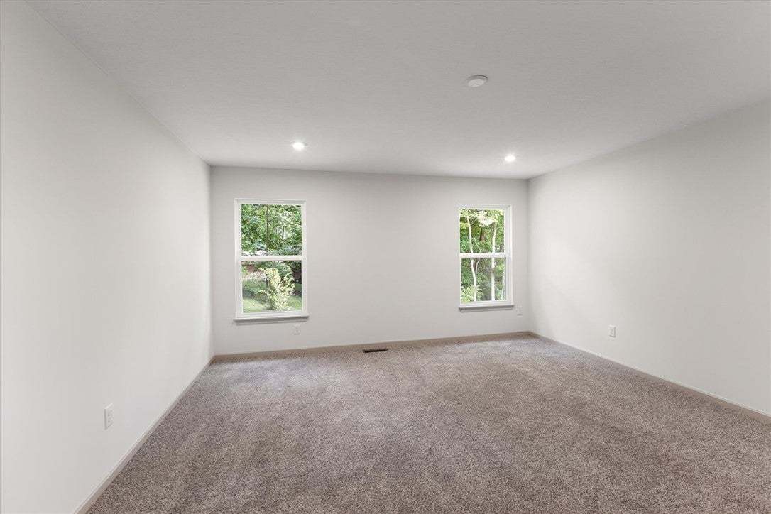 Plush carpeting and recessed lighting create a com