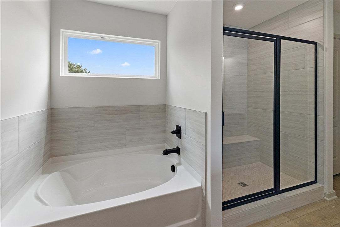 Tiled walls frame a deep soaking tub and a walk-in