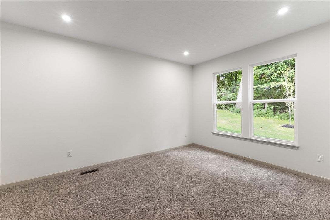 Plush carpeting and recessed lighting frame peacef