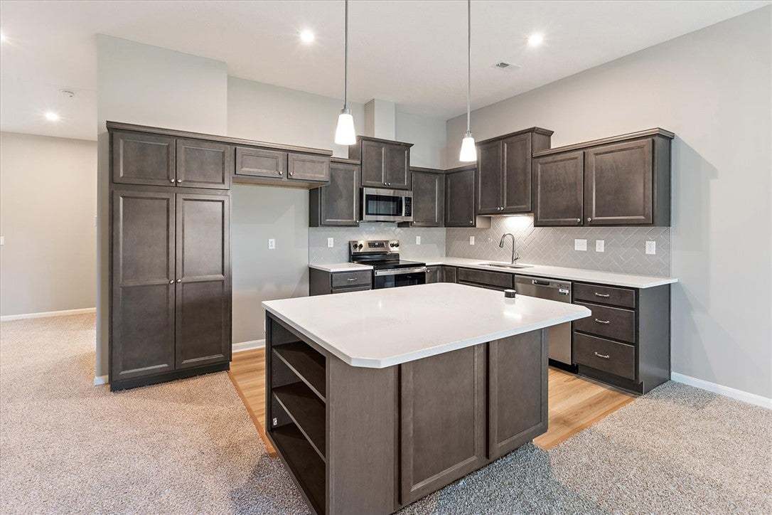 Rich dark cabinetry and a central island ground th