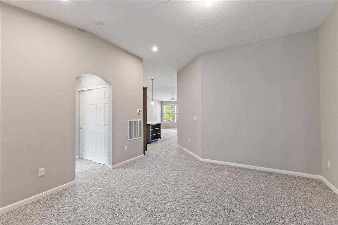 Plush carpeting and an arched doorway define this