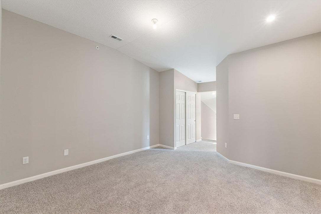 A spacious carpeted interior displays smooth neutr