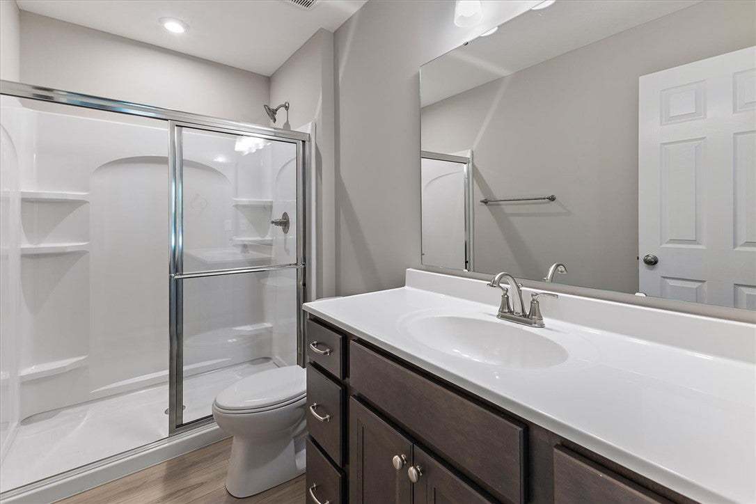 A modern vanity with dark cabinetry sits adjacent
