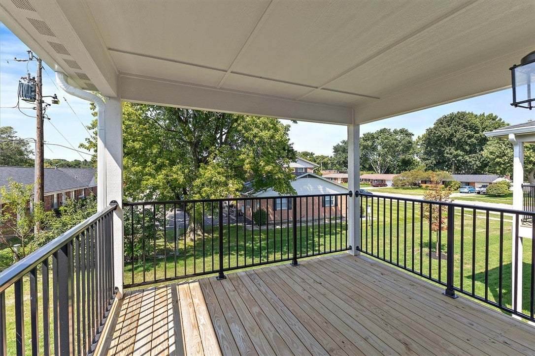 A spacious covered deck with wood plank flooring a