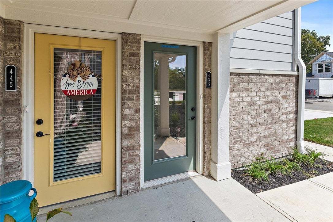 A covered concrete entryway features distinctive b