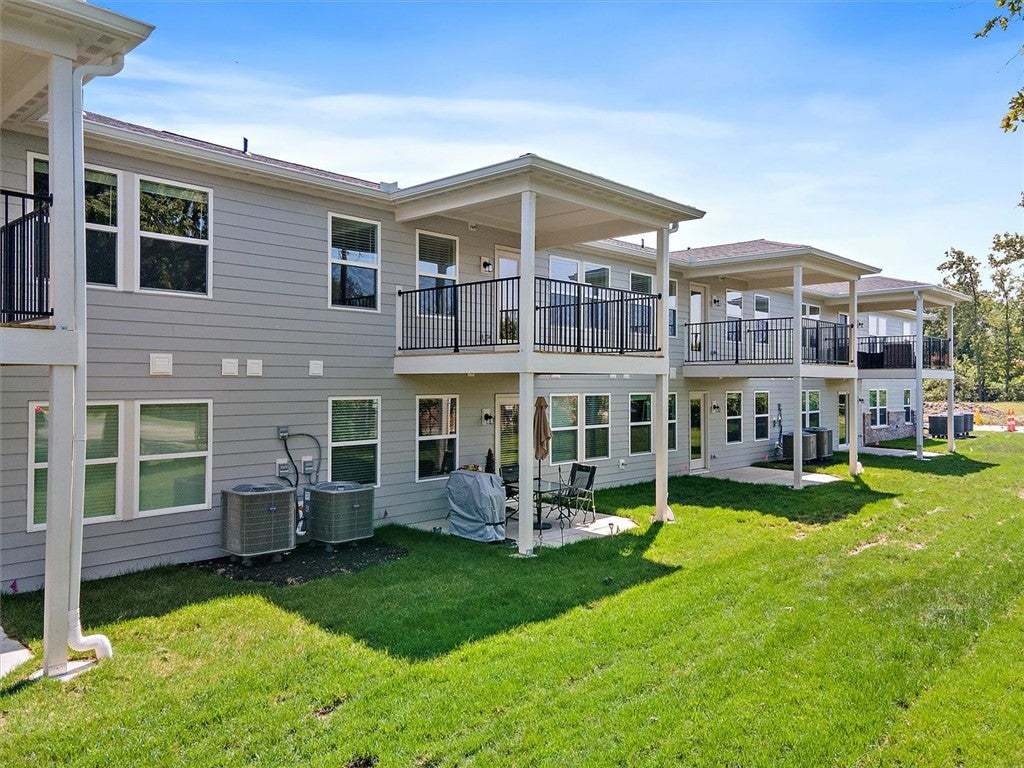 A manicured green lawn borders the private covered