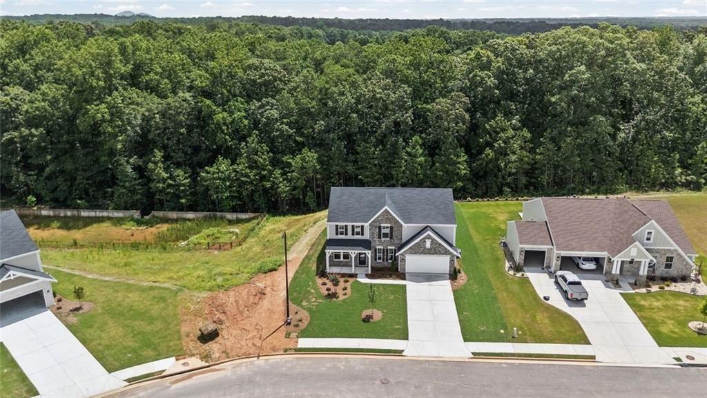 Two-story residence featuring a stone and siding facade, a covered front porch, and a two-car garage