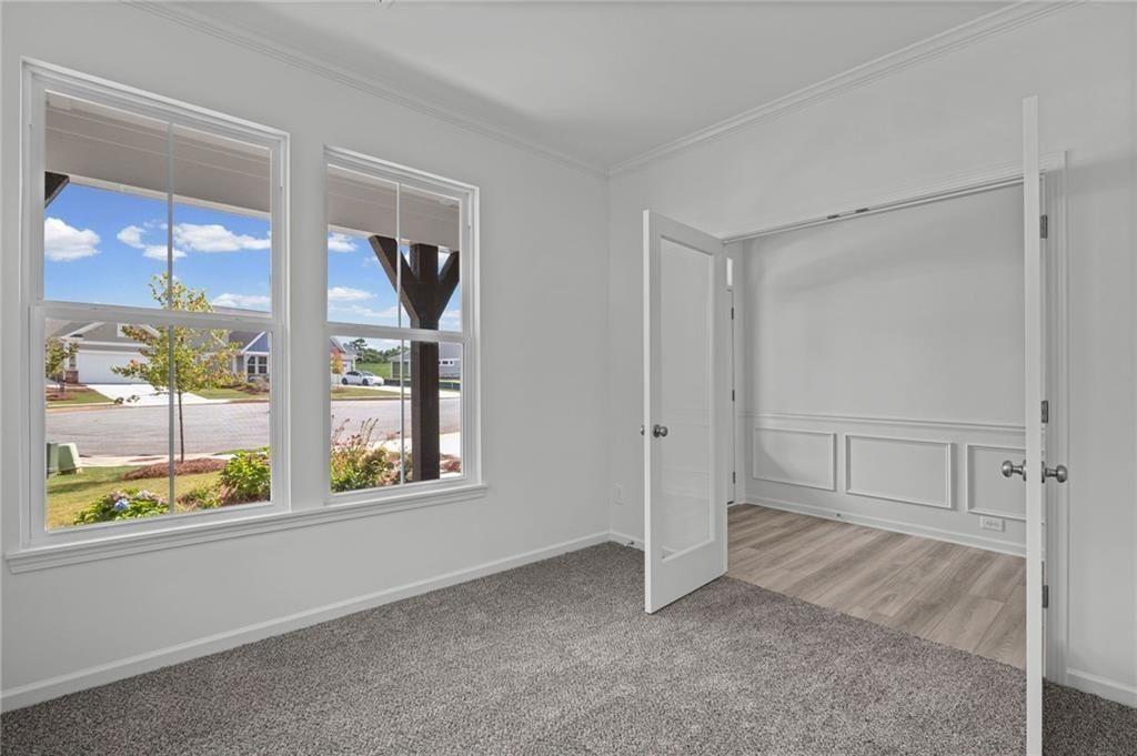 Room featuring two windows, crown molding, and grey carpet
