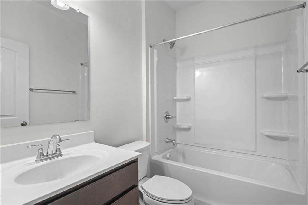 Bathroom featuring a white vanity with an integrated sink, chrome faucet, and dark wood-finish cabinetry