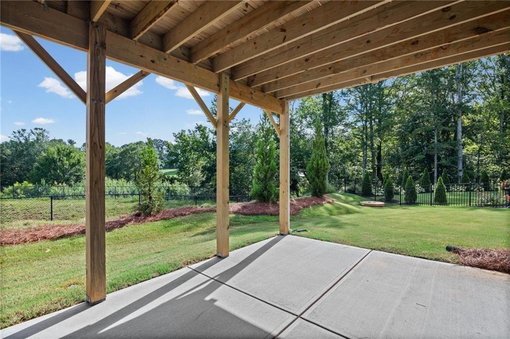 Covered concrete patio with exposed wood joists and support beams