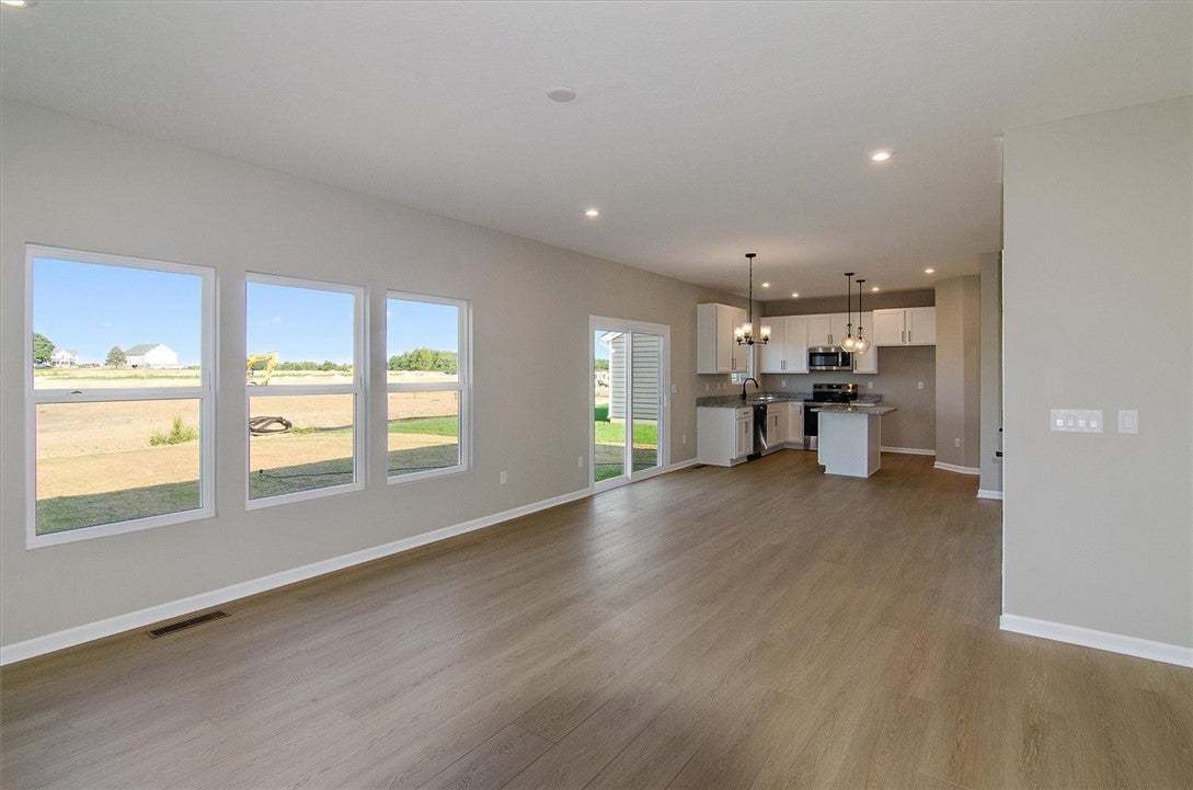 Sunlight streams through large windows across an e