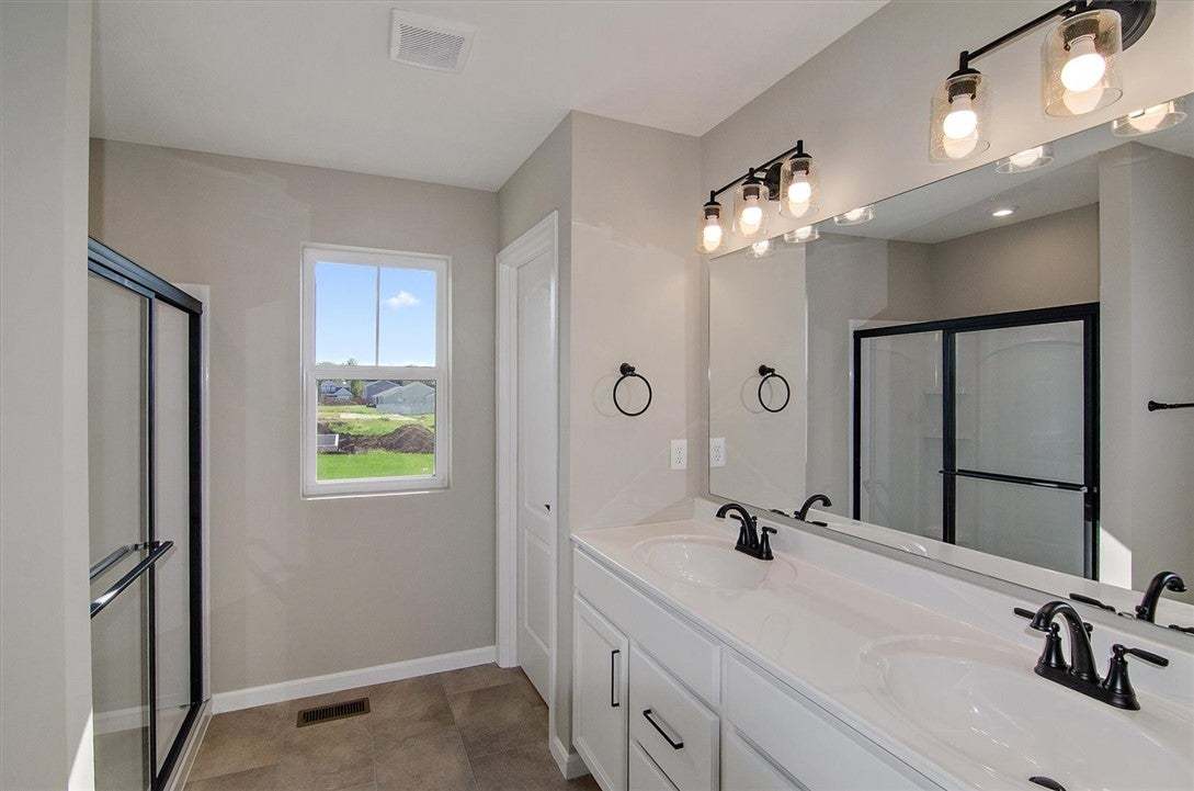 A spacious double vanity and tile flooring define