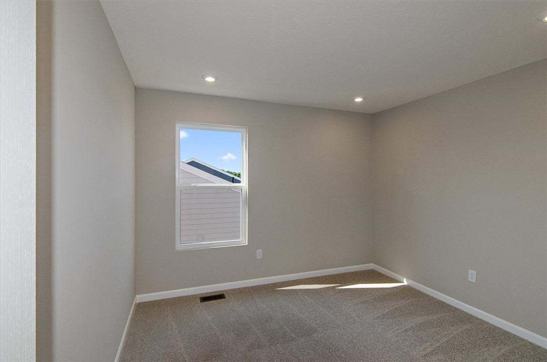 A single window illuminates this carpeted room fea