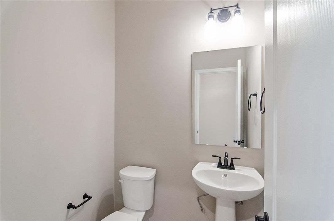 A classic pedestal sink paired with a frameless mi