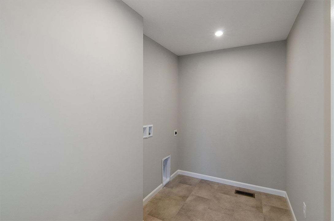 A dedicated laundry nook features durable tile flo