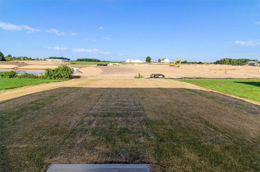 A spacious grassy yard overlooks vast open land un