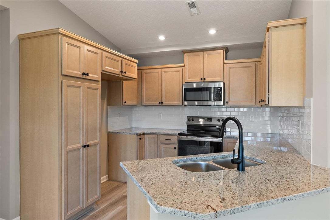 Natural wood cabinetry and granite countertops fra