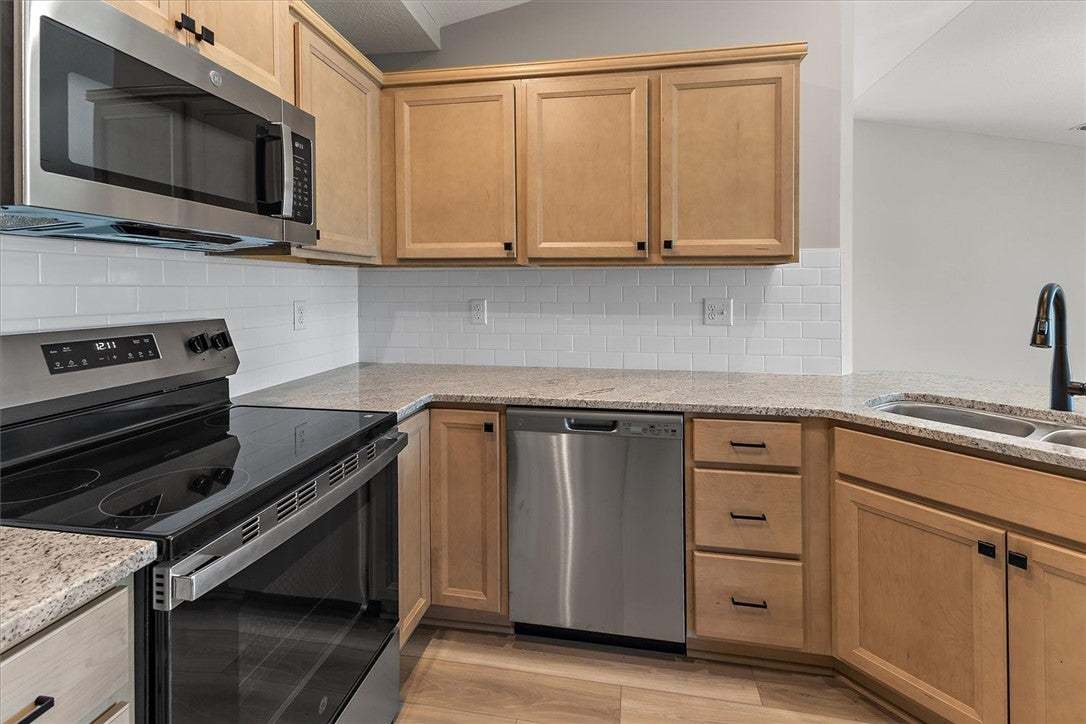 Natural wood cabinetry pairs with durable stone co