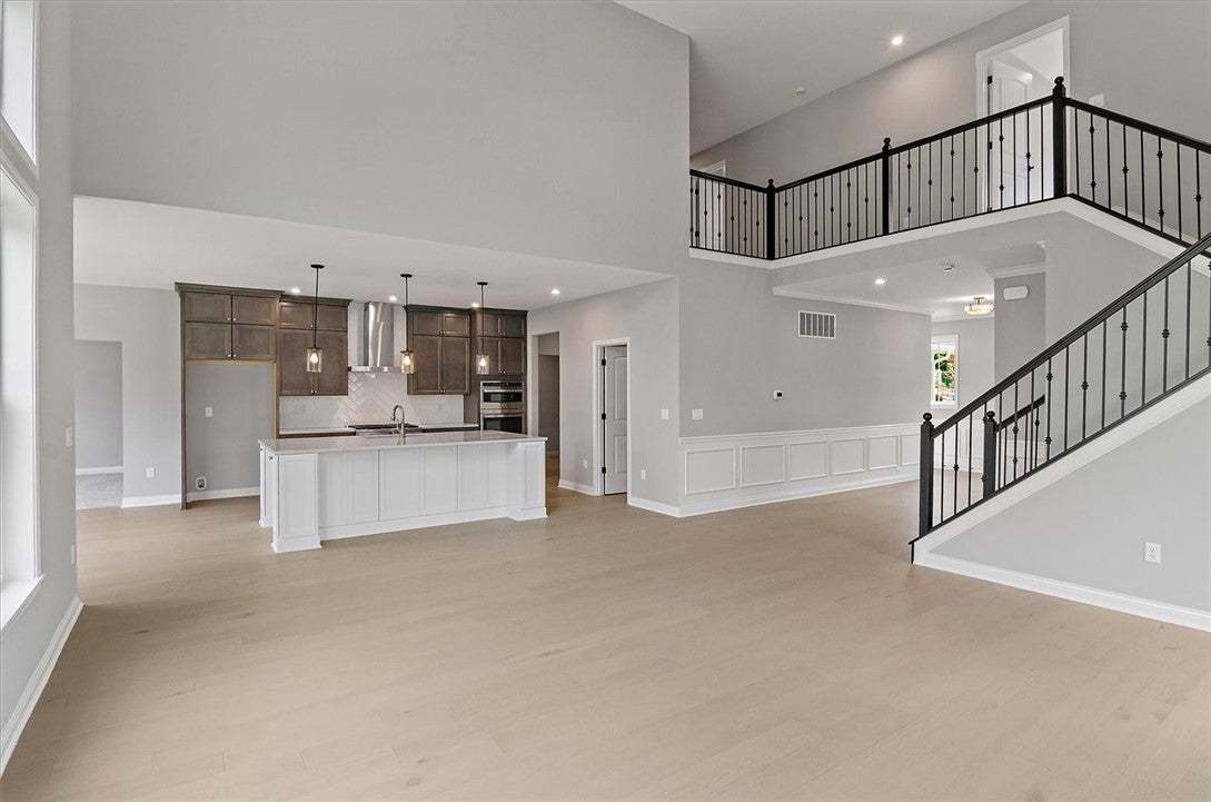 Soaring ceilings and light wood floors define this