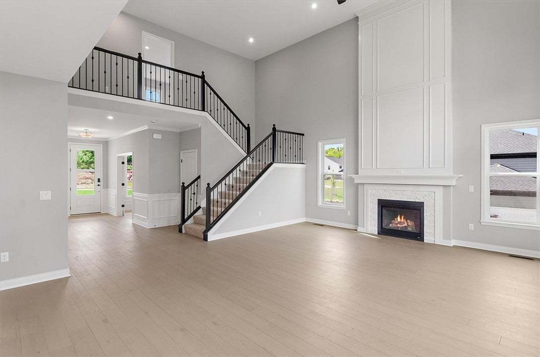 Sleek hardwood floors and a soaring fireplace defi