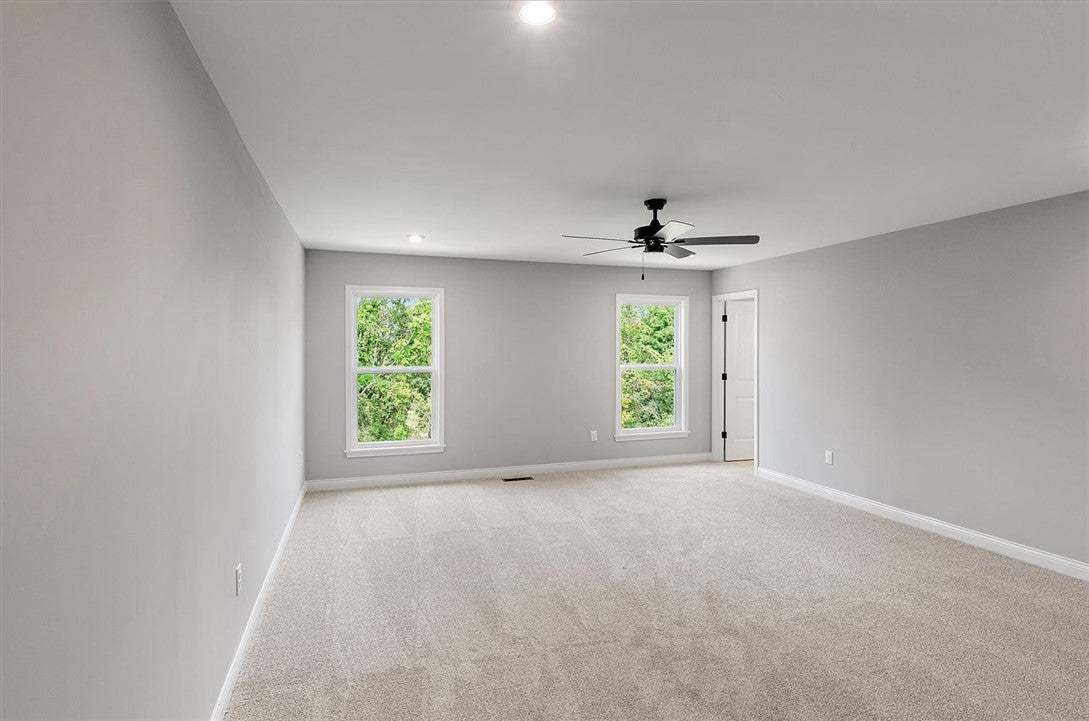 Plush carpeting and dual windows overlooking natur