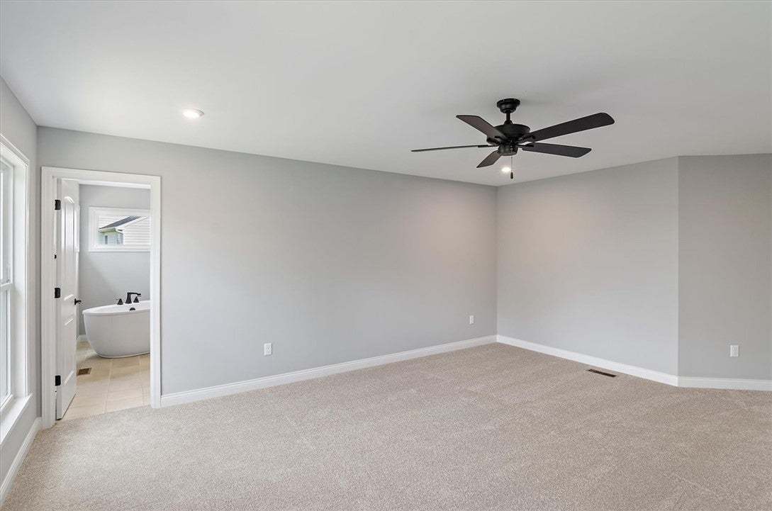 Plush carpeting anchors this spacious bedroom feat