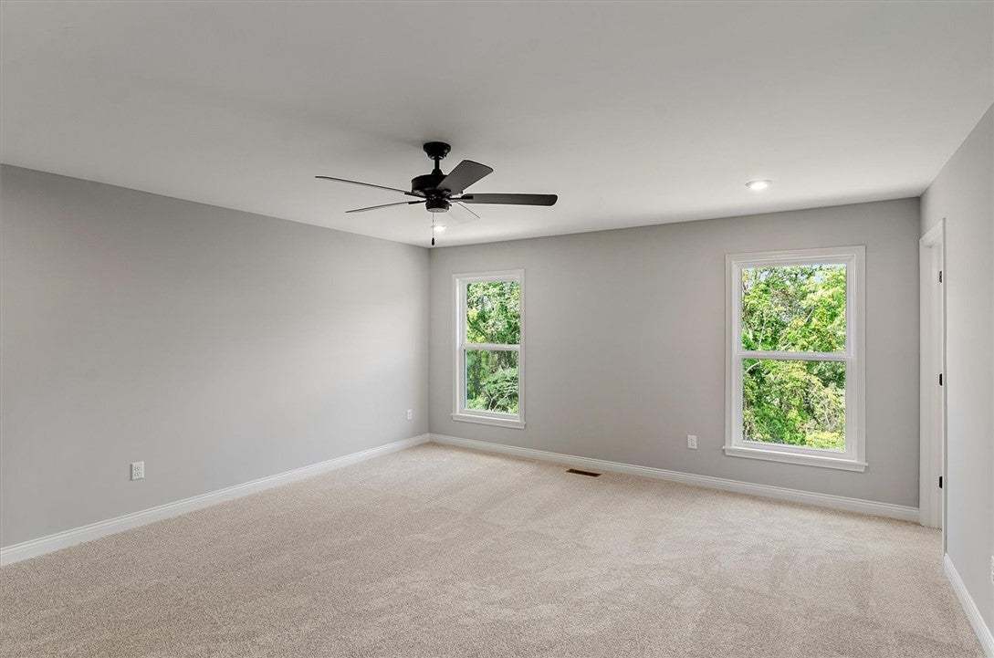 A spacious bedroom features plush carpeting, neutr