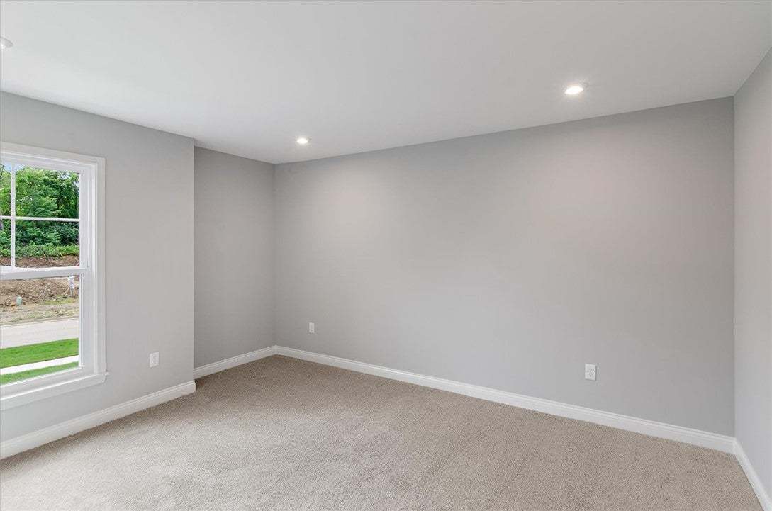 A quiet bedroom offers recessed lighting and textu