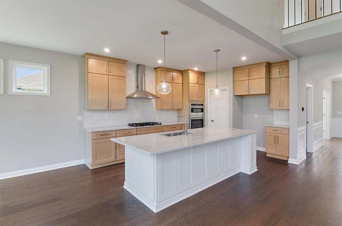 Rich hardwood floors anchor this light-filled culi