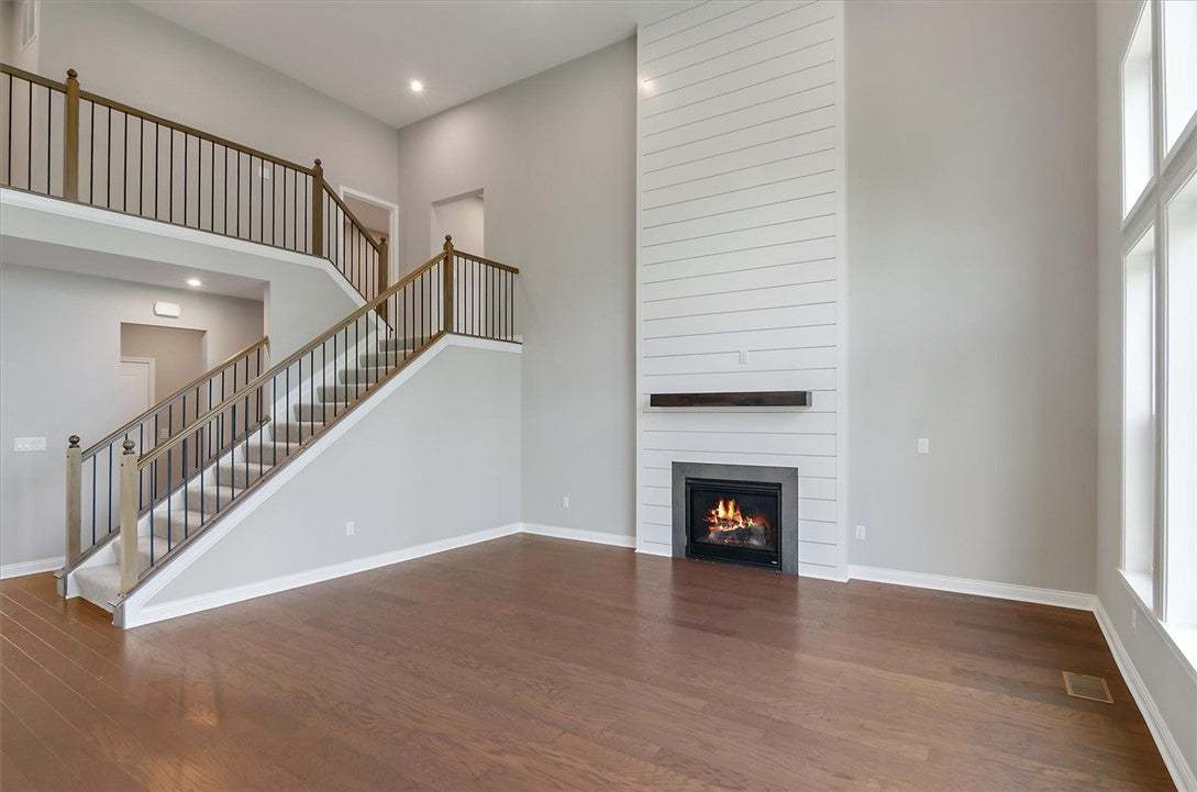 Hardwood floors and a towering shiplap fireplace d