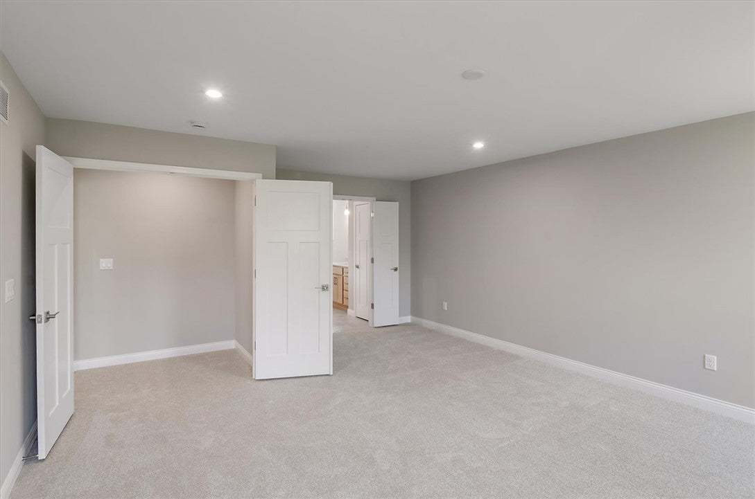 Plush carpeting anchors this spacious bedroom feat