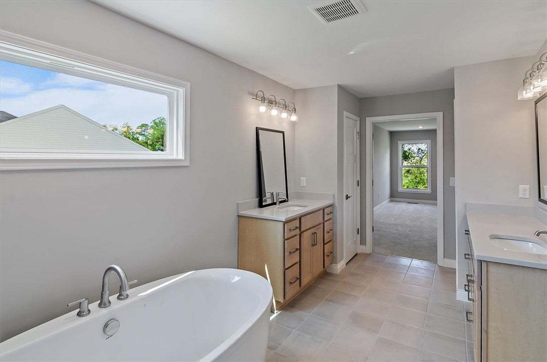 A freestanding tub and dual vanities anchor this s