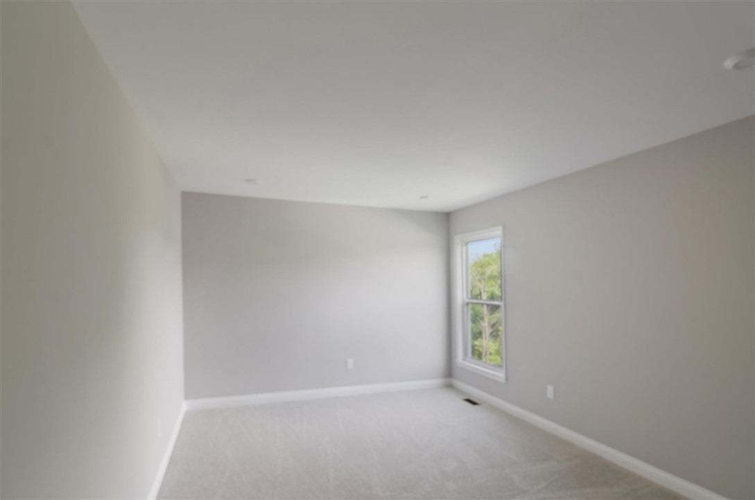 Smooth plaster walls and neutral carpeting define