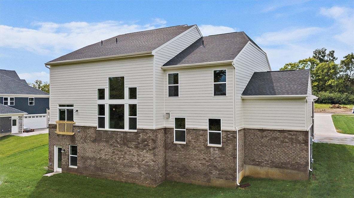 A classic brick foundation and light siding highli