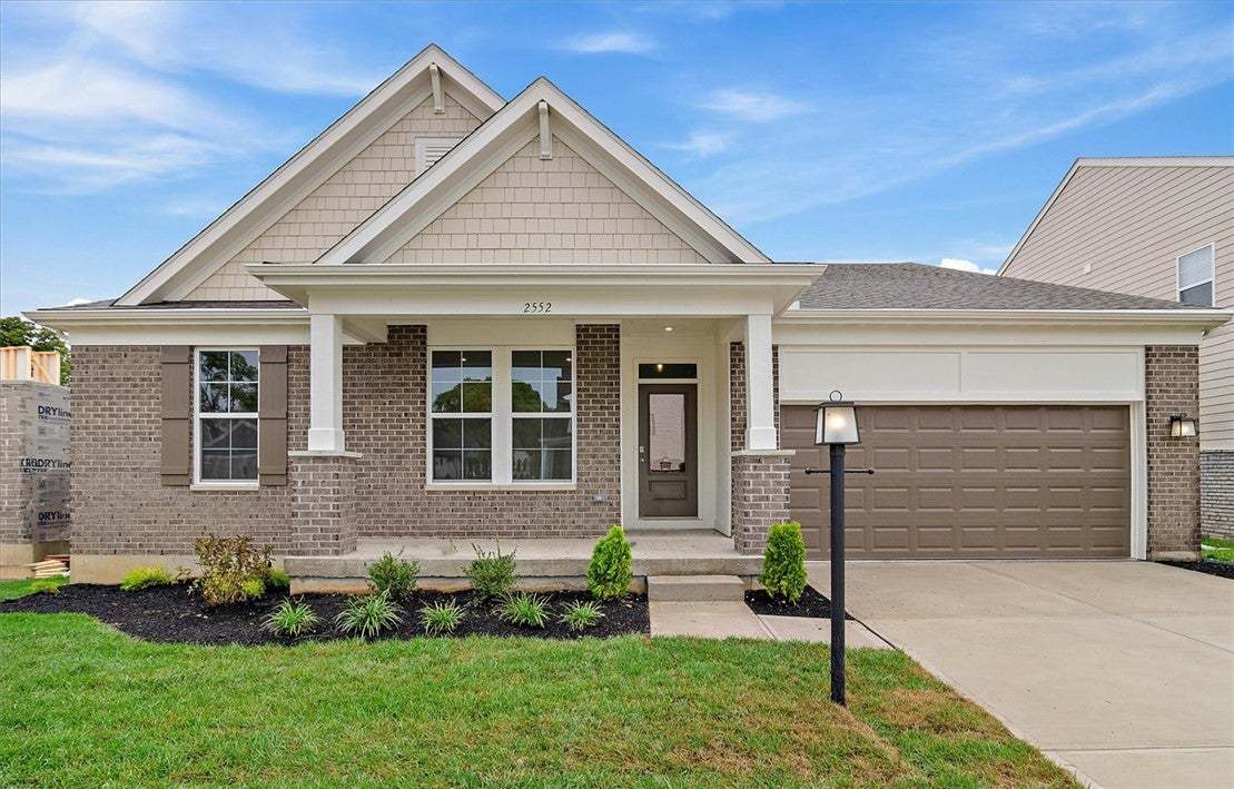 A classic brick and siding exterior features a wel