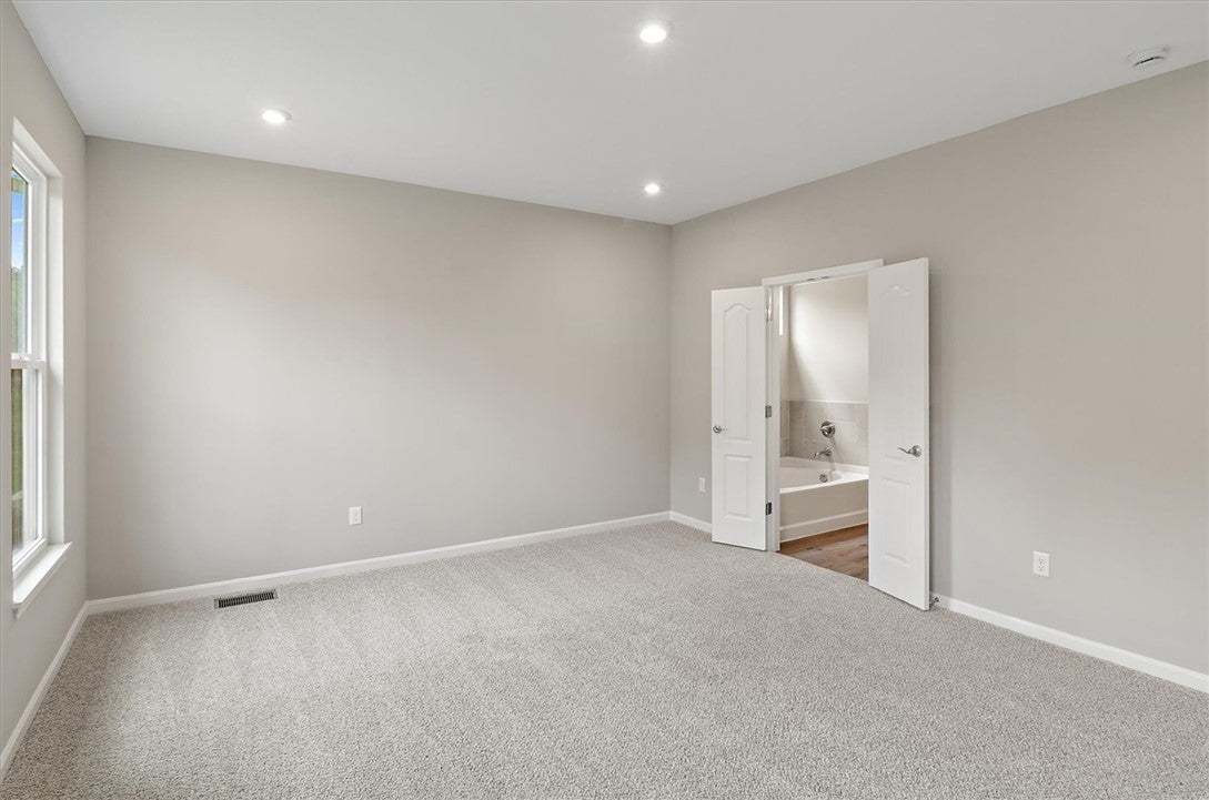 Recessed lighting and soft carpeting create a sere