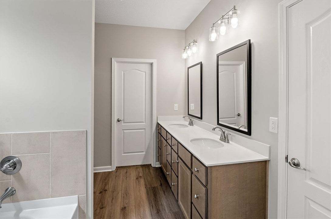 A spacious double vanity and warm wood-look floori