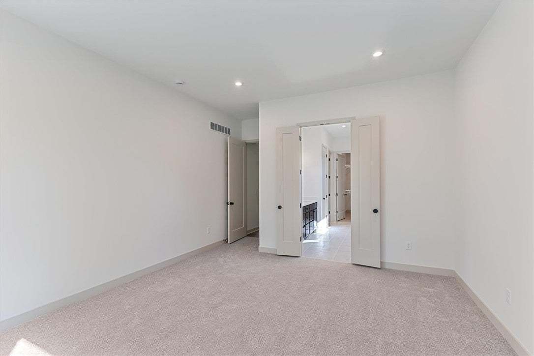 A spacious bedroom offers plush carpeting and doub