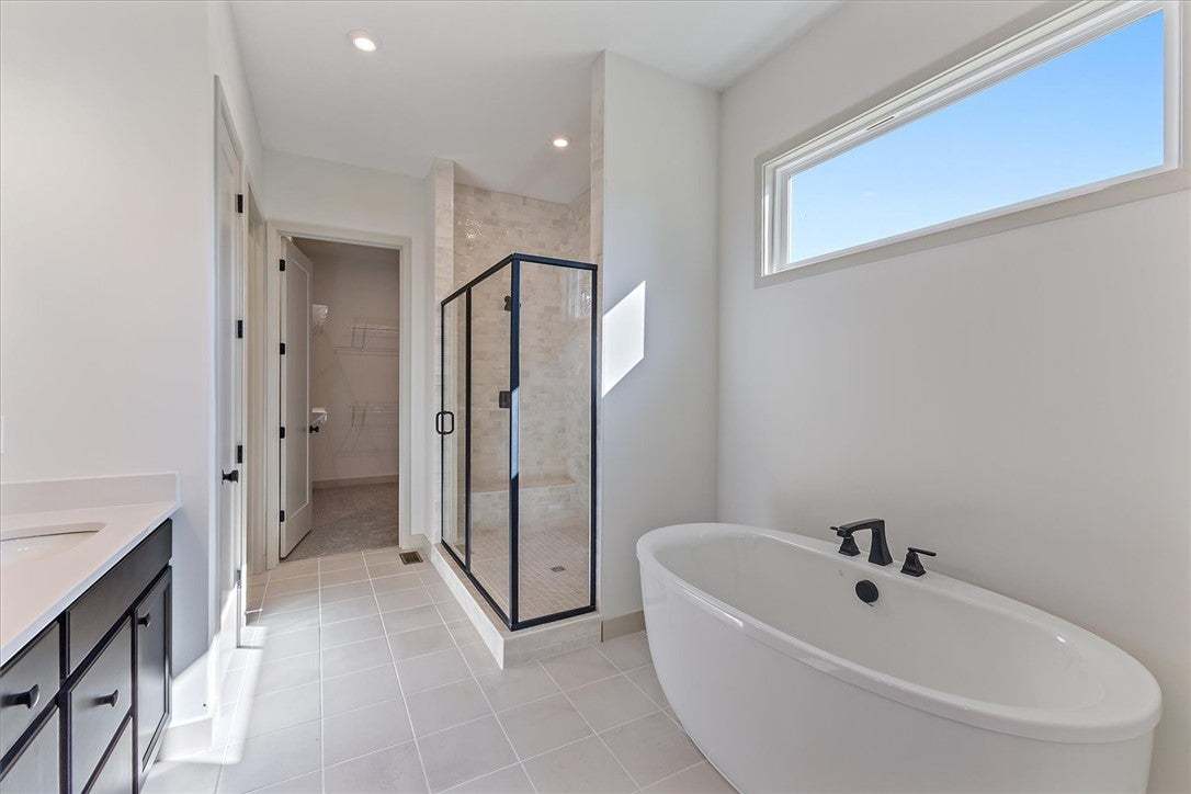 A deep soaking tub sits beneath a high clerestory