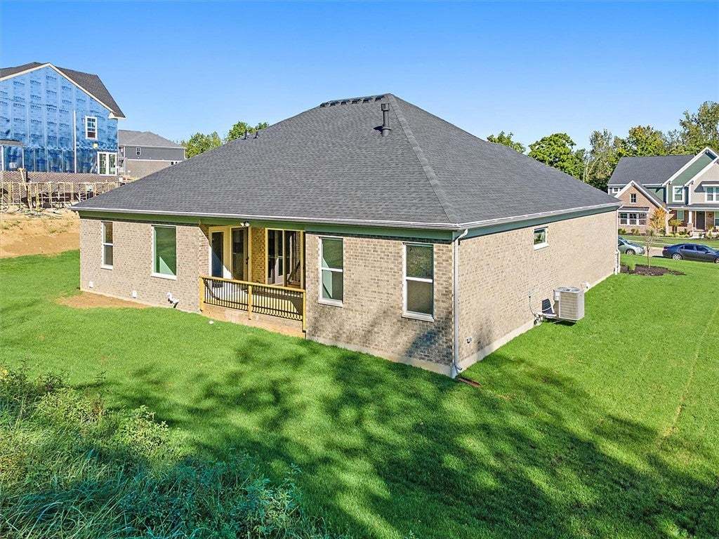 A spacious green lawn sits behind this brick home
