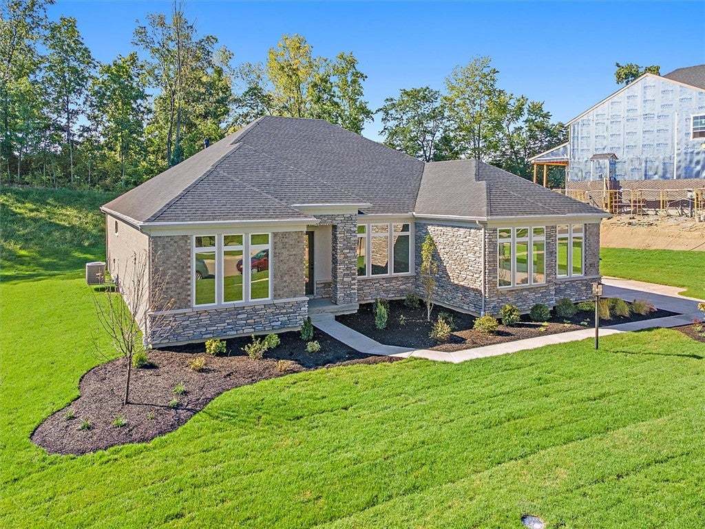 Manicured lawns surround this modern stone and bri