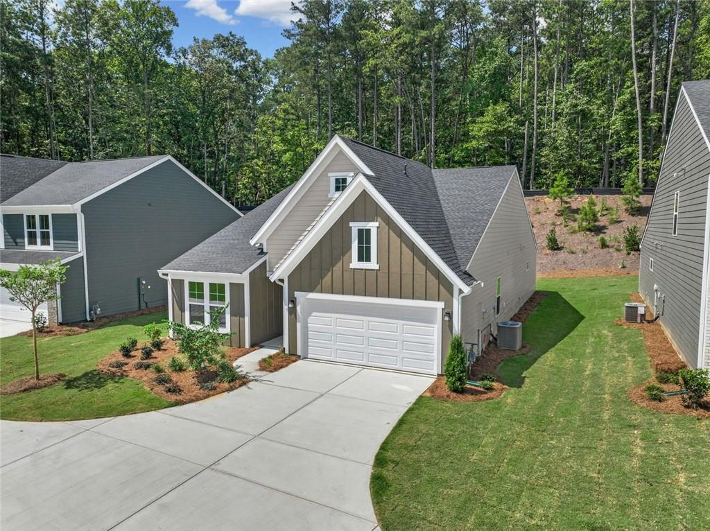 Contemporary craftsman-style residence featuring a dark gray vertical siding gable with white trim