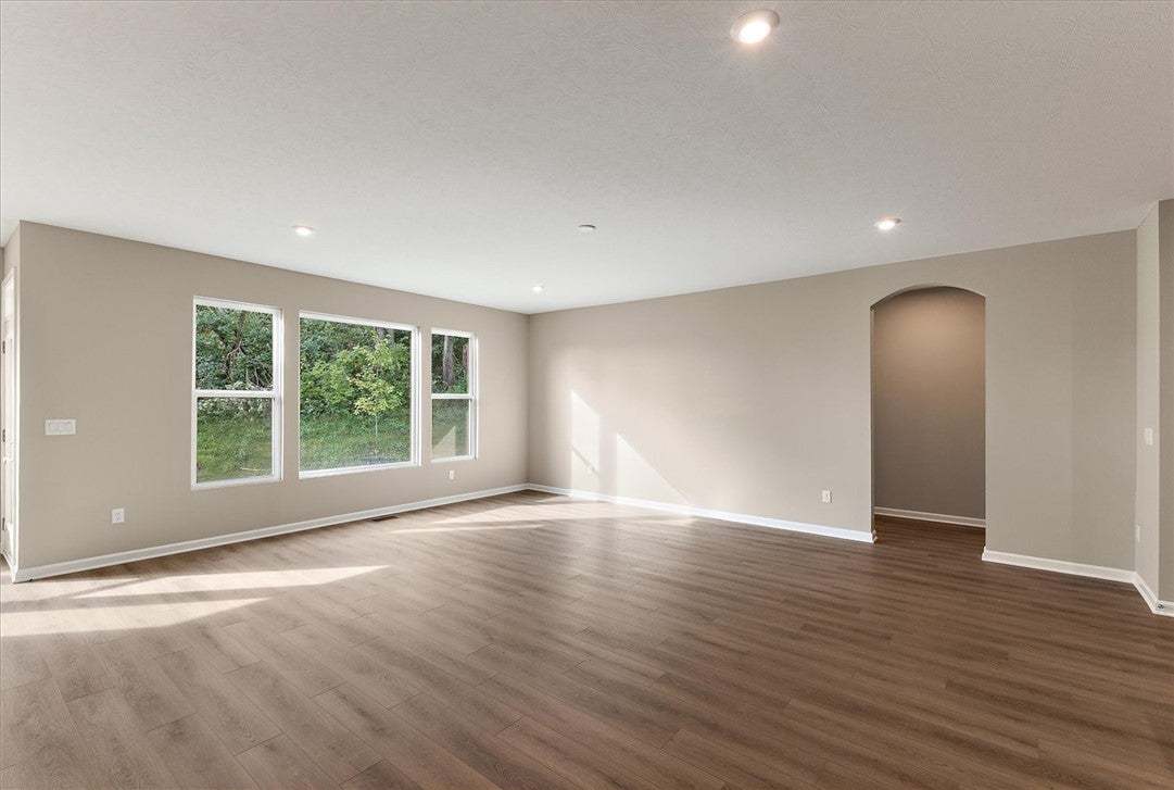 Smooth wood floors and recessed lighting anchor th