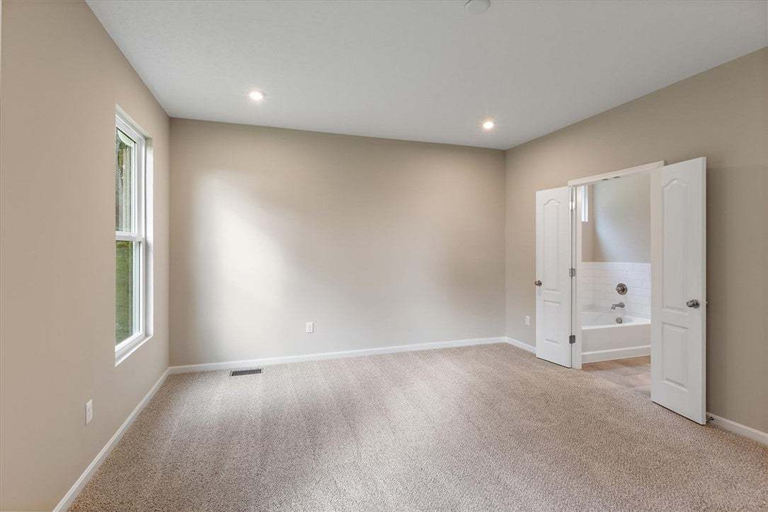 Plush carpeting and recessed lighting create a com