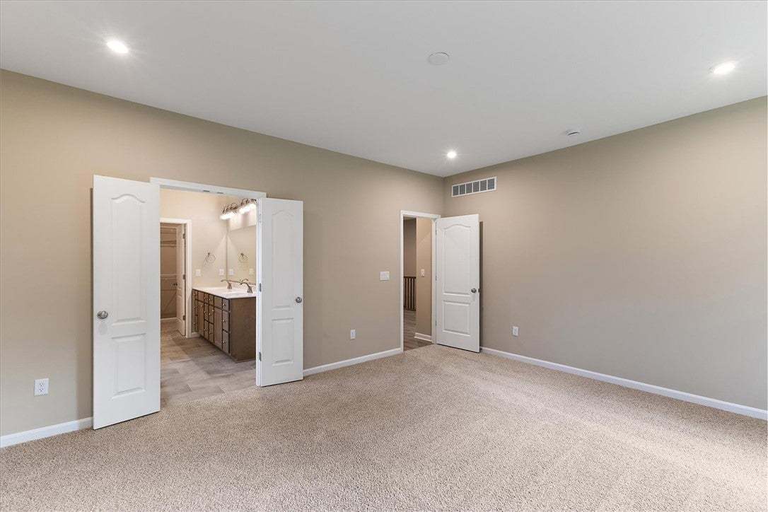 Plush carpeting and recessed lighting create a com