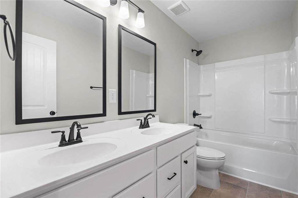 Dual vanity with undermount sinks, matte black fixtures, and a white countertop